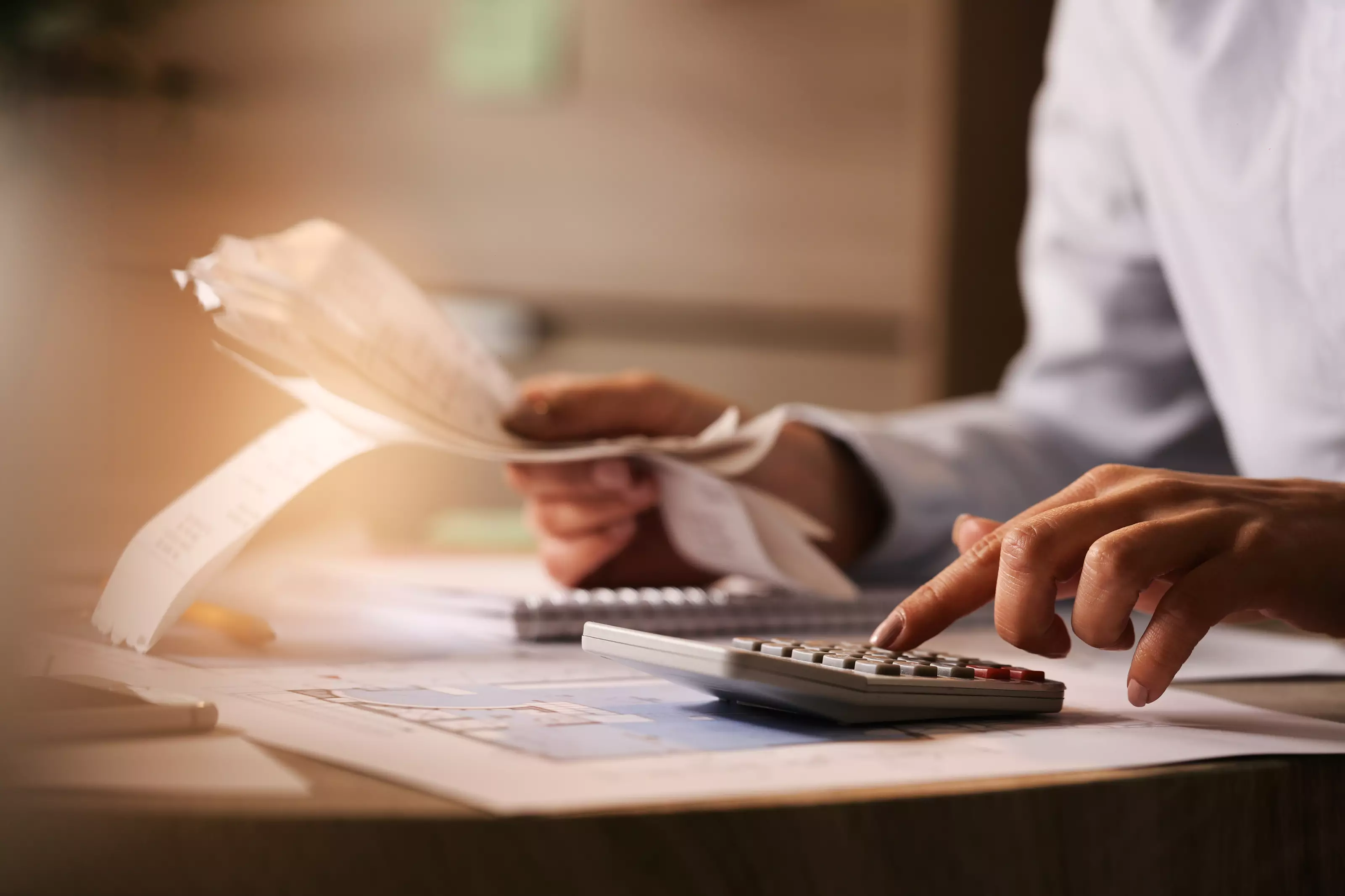 closeup-economist-using-calculator-while-going-through-bills-taxes-office_183
